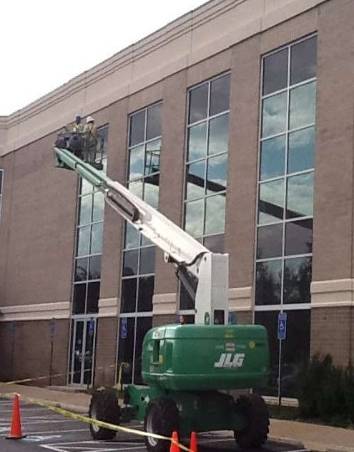 Technician re-caulking old window frame for waterproofing repair work